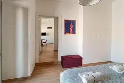 a white room with a bed and a red ottoman at Little Red Apartment in Rome