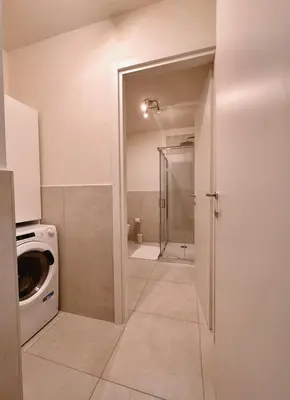 a bathroom with a shower and a washing machine at Caesar's Suite Trastevere in Rome