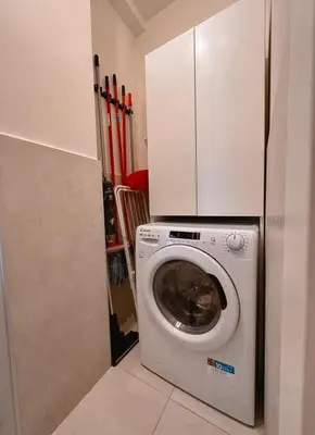 a washer and dryer in a kitchen with a cabinet at Caesar's Suite Trastevere in Rome