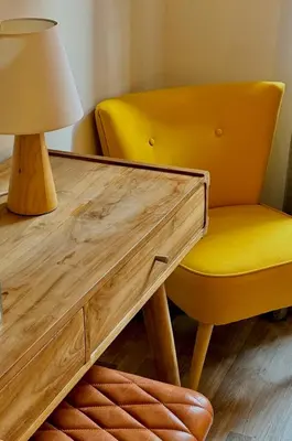 a yellow chair sitting next to a desk with a lamp at Suite Castelfidardo 50 in Rome