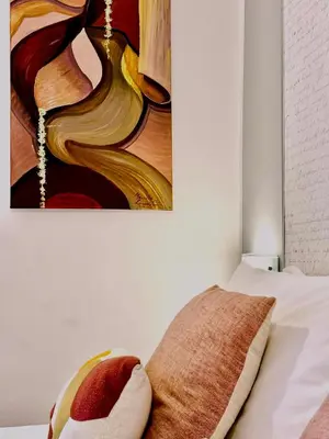 a bedroom with a painting on the wall next to a bed at Suite Castelfidardo 50 in Rome