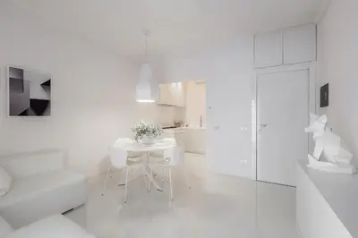 a white kitchen with a white table and chairs at Luxury White in Rome