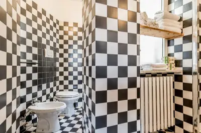 a bathroom with a black and white checkered wall at Trastevere Holiday in Rome