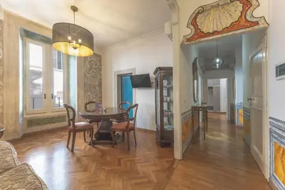 a living room with a table and a dining room at Palazzo Pamphili Apartment in Rome