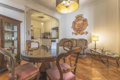 a dining room with a glass table and chairs at Palazzo Pamphili Apartment in Rome