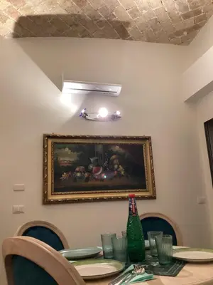 a dining room table with a painting on the wall at Bretone XI b&b in Rome