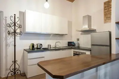 a kitchen with white cabinets and a refrigerator at Castro Pretorio Cozy apartment in Rome
