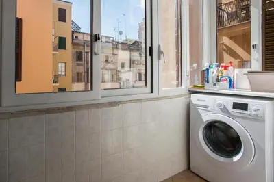 a laundry room with a washing machine and windows at Castro Pretorio Cozy apartment in Rome