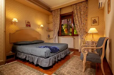 a bedroom with a bed and a chair and a window at Family Suite in Rome