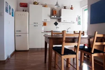 a kitchen with a table and chairs and a refrigerator at Mickey's House in Rome