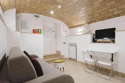 a living room with a couch and a table and a tv at Domus Mariani - Cremera by Ghor in Rome