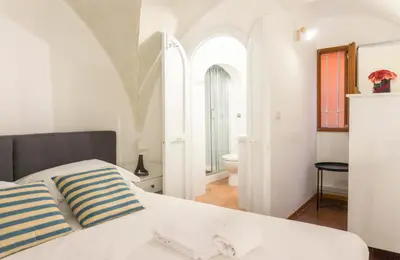 a white bedroom with a bed and a bathroom at Introvabile! Casa Roma centro, Campo de Fiori in Rome