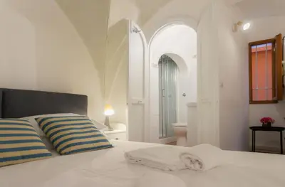 a white bed with two pillows and a bathroom at Introvabile! Casa Roma centro, Campo de Fiori in Rome