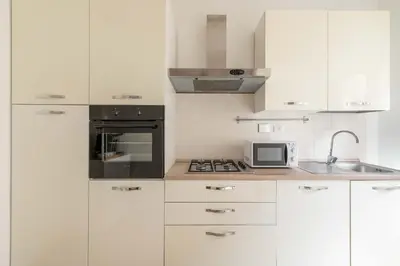 a white kitchen with white cabinets and a microwave at LoveRhome Apartment 2 in Rome