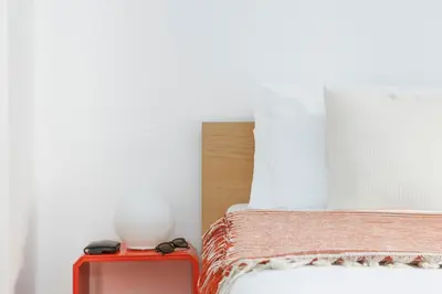 a bed with a white vase on top of a table at Trastevere Zen Home-ZENO 33 in Rome