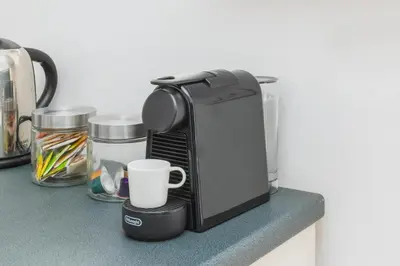 a coffee maker on a counter with a cup at Trastevere Zen Home-ZENO 33 in Rome