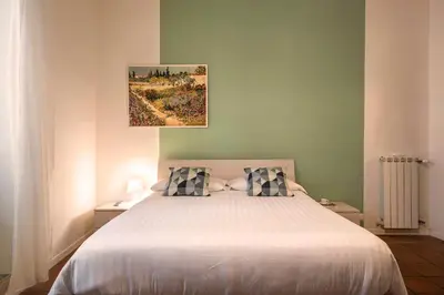 a bedroom with a white bed with two pillows at Nettuno Apartment in Rome