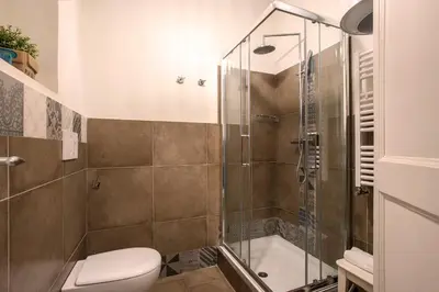 a bathroom with a shower and a toilet at Nettuno Apartment in Rome