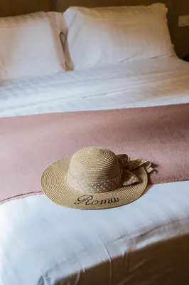 a straw hat sitting on top of a bed at 163 BOUTIQUE HOTEL in Rome