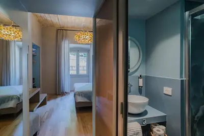 a bathroom with a sink and a bed and a mirror at 163 BOUTIQUE HOTEL in Rome