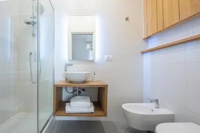 a bathroom with a sink and a toilet and a mirror at Benny Gold - Elegant apartment right next to the METRO in Rome