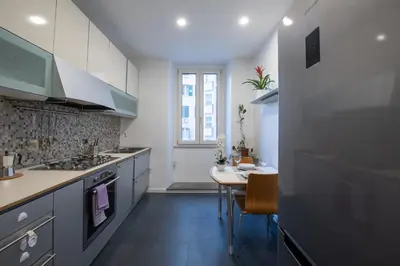 a kitchen with a table and a dining room at Benny Gold - Elegant apartment right next to the METRO in Rome