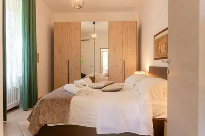 a bedroom with a bed with white sheets and a mirror at St.Peter station Holiday apartment in Rome