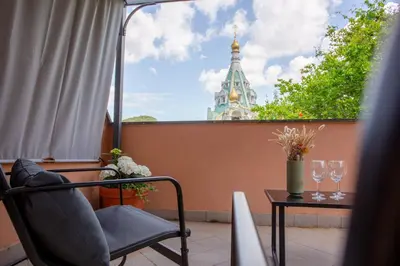 a balcony with a chair and a table and a tower at St.Peter station Holiday apartment in Rome