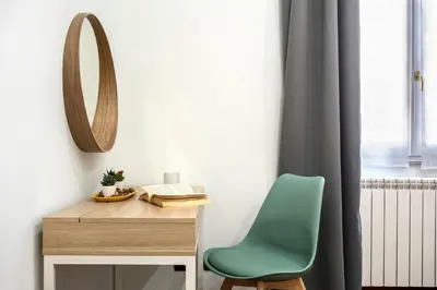 a desk with a green chair and a mirror at Montebello Style in Rome