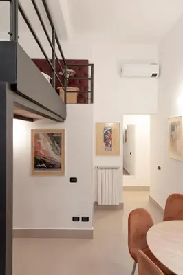 a room with a table and some paintings on the wall at Restart Accommodations Colle Oppio e Paganini in Rome