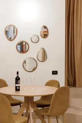 a table with chairs and mirrors on the wall at Restart Accommodations Colle Oppio e Paganini in Rome