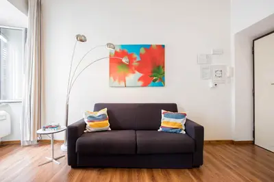 a living room with a couch and a painting on the wall at Minerva 2 Apartment in Rome