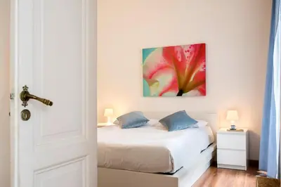 a bedroom with a bed with a red flower painting on the wall at Minerva 2 Apartment in Rome