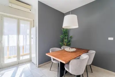 a dining room with a wooden table and chairs at Maison Lumiere, Design Apt 5 min from Tiburtina Station in Rome