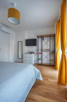 a bedroom with a white bed and yellow curtains at Home Trastevere.62 in Rome