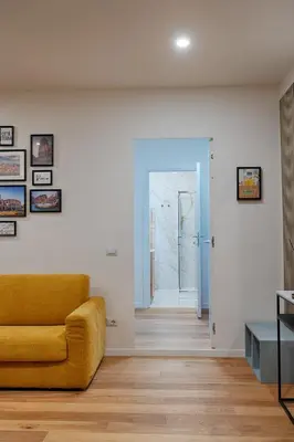 a living room with a yellow couch and a hallway at Home Trastevere.62 in Rome