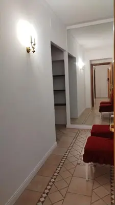 a hallway with red chairs and a wall with shelves at B&B L'Esquilina in Rome