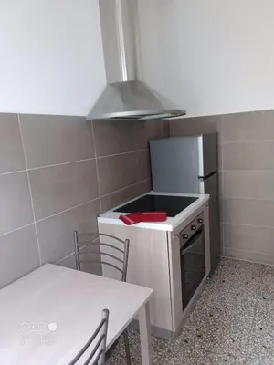 a small kitchen with a stove and a table and a stove top oven at Domus Gianicolense in Rome