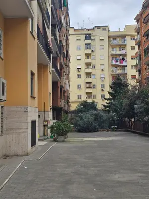 an empty parking lot in front of some buildings at Corona House in Rome