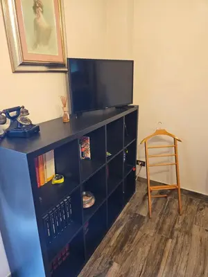a black entertainment center with a flat screen tv on top at Corona House in Rome