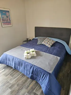a blue bed with two towels on top of it at Corona House in Rome