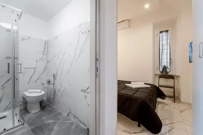 a bathroom with a shower and a toilet and a bed at TERMINI HOLIDAY in Rome