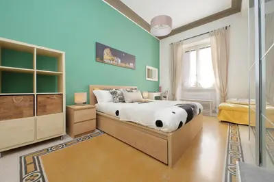 a bedroom with a bed and a blue wall at CASA GIULIANA - 3BR 2BATH, 2nd floor historic mansion with lift & doorman, chic, family friendly with baby equipment, 600 meters from Vatican & Ottaviano metro, quietest area of P R A T I wealthy, secure, accessible district - Guest care in 4 languages in Rome