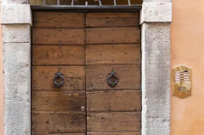 a wooden door on a building with a phone at Rome as you feel - Vicolo delle Grotte in Rome