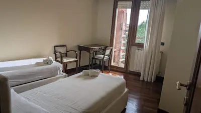 a room with two beds and a table and a window at Appia Nuova Lucrezia Apartment in Rome