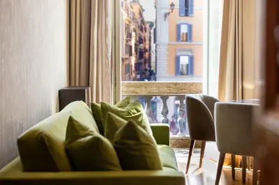 a green couch sitting in front of a window at Residenza Pierret in Rome