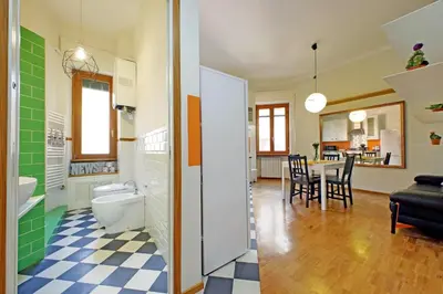 a bathroom with a toilet and a dining room at Monteverde family apartment in Rome