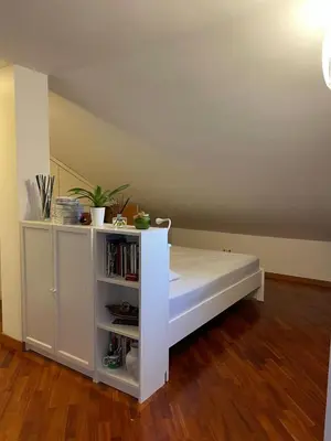 a white bed in a room with a book shelf at Trastevere Lenci House in Rome