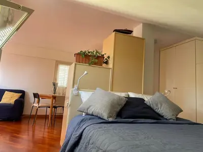 a bedroom with a bed and a table and a chair at Trastevere Lenci House in Rome