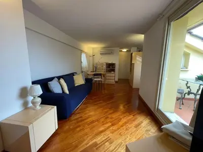 a living room with a blue couch and a table at Trastevere Lenci House in Rome